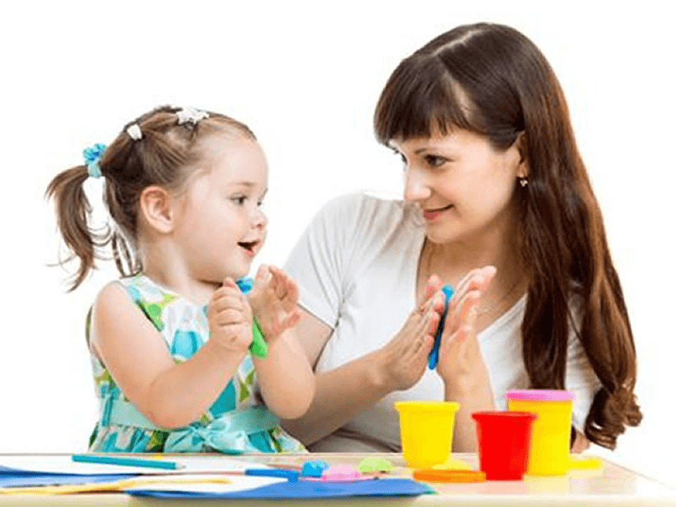 A woman and a child engaged in a hands-on ABA therapy activity using colorful modeling clay to support learning and behavioral development.