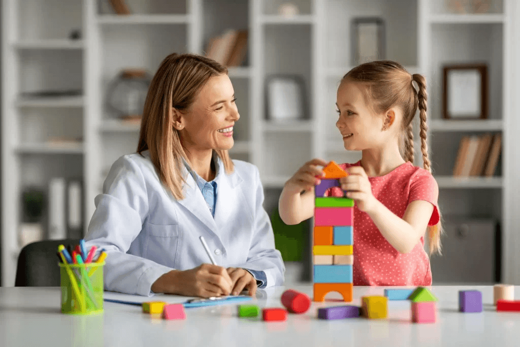 A child engages in developmental play therapy with a professional, illustrating autism intervention techniques.