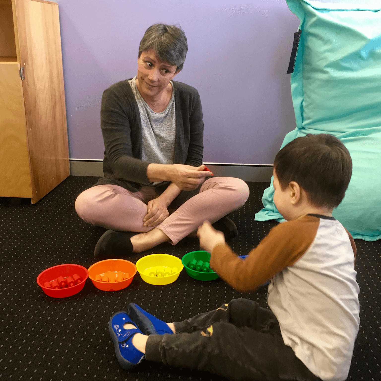 Early Start Denver Model therapy session using color sorting and play to engage a young child with autism.