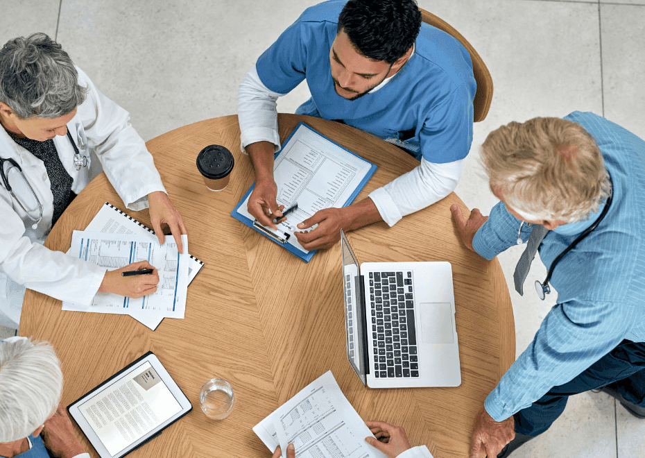 Multidisciplinary healthcare team collaborating on case evaluation for autism assessment.