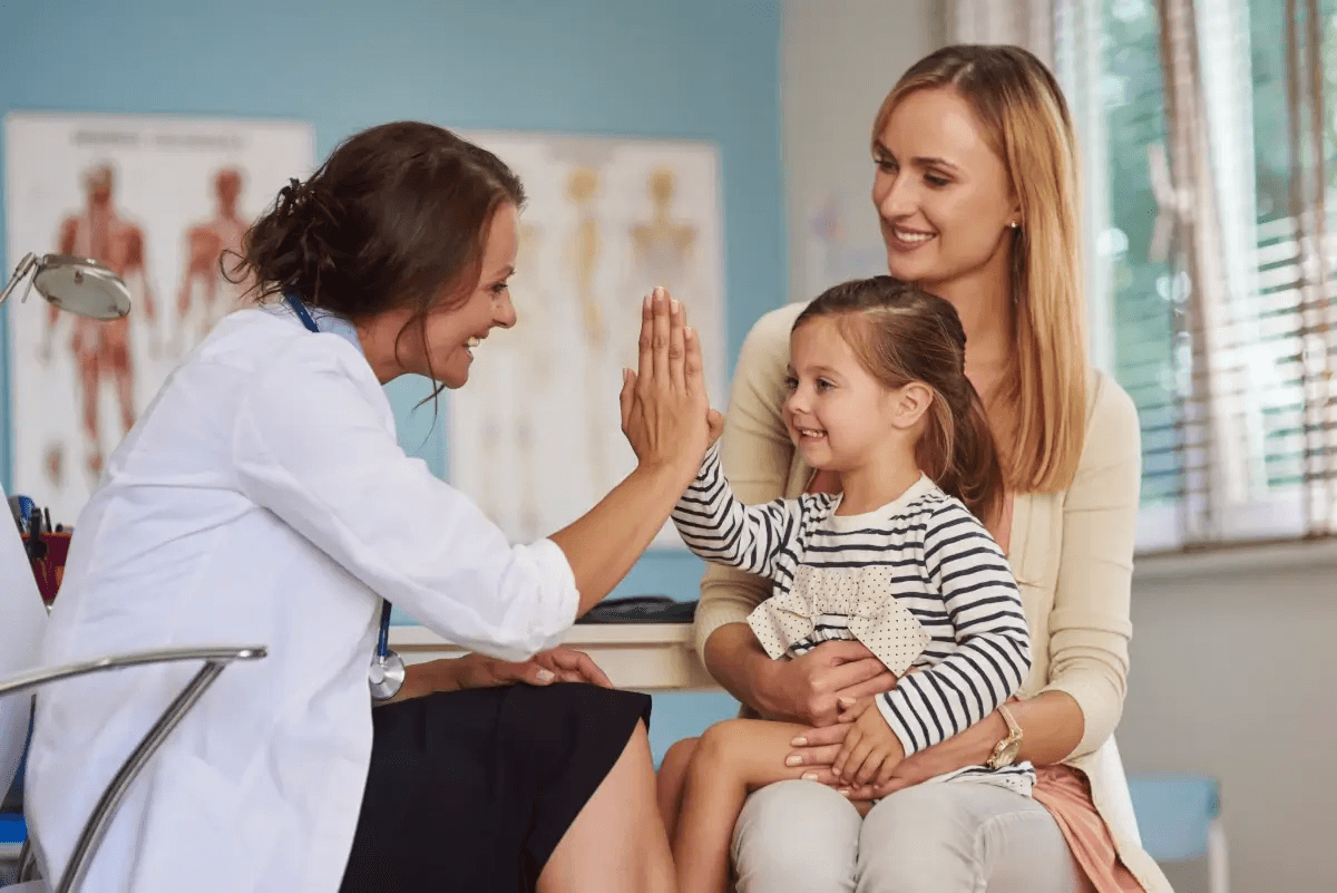 A neuropediatrician consulting with a child and mother in a clinical setting related to autism diagnosis.