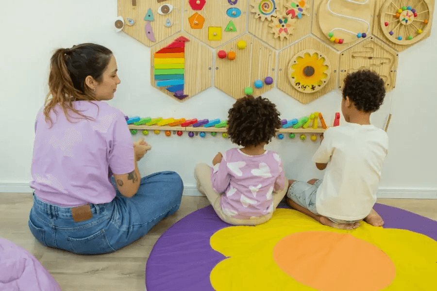 Child engaged in therapeutic activities with an adult using colorful interactive toys in a child-friendly environment.